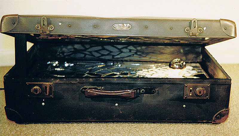 1988-07-Der-unendliche-Koffer-2-Spiegel-Keramik-auf-Holz-und-Gluehbirne-im-Koffer-18x65x39cm